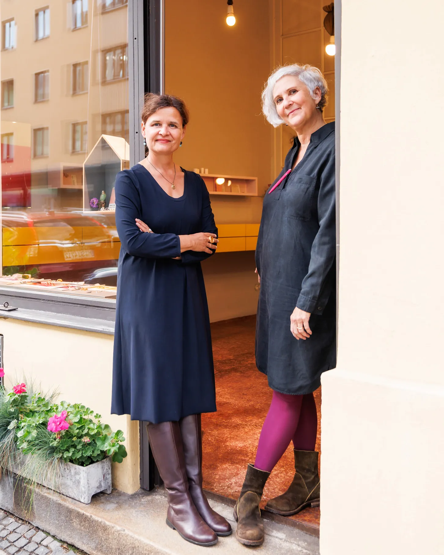 Zwei Inhaberinnen eines Schmuckladens stehen entspannt lächelnd in der Eingangstür, links
